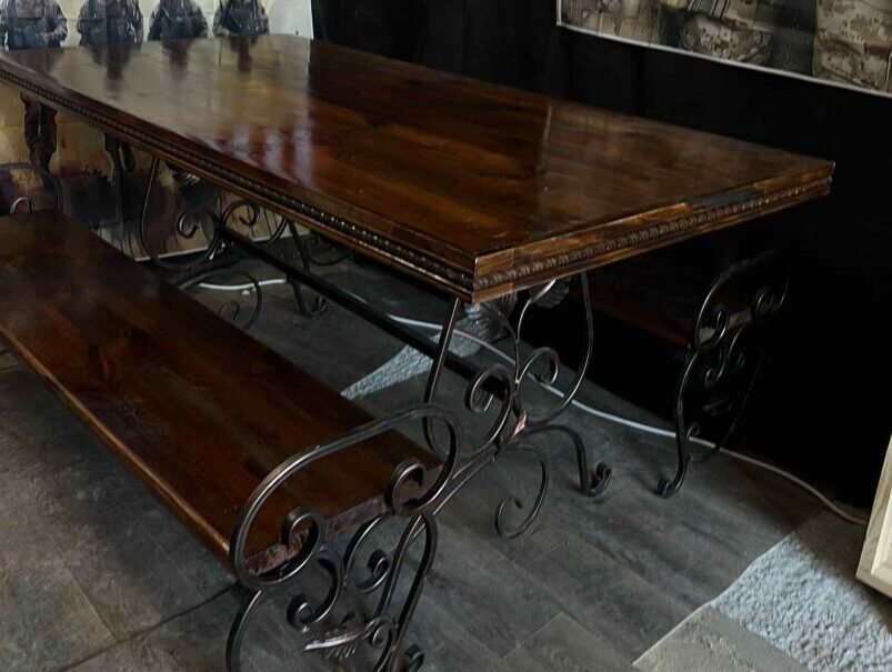 Long dining table on forged iron legs